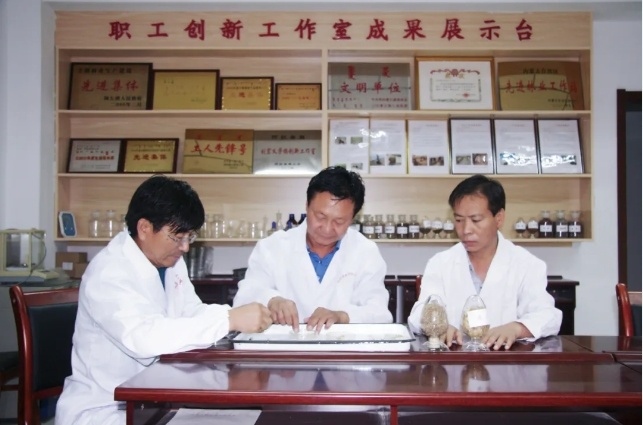 刘宏义（中间）和工作人员讨论种植技术、经验。（来源：阿拉善左旗融媒体中心）